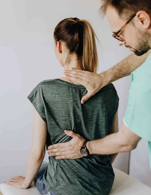 Person legt einer anderen Person die Hand auf den R&uuml;cken