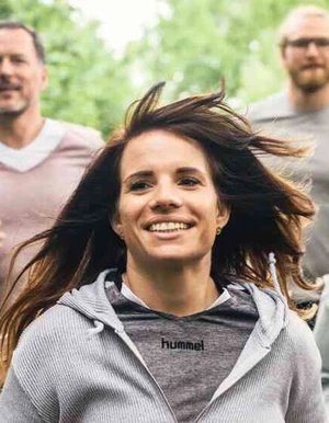 mehrere Personen joggen durchs Gr&uuml;ne