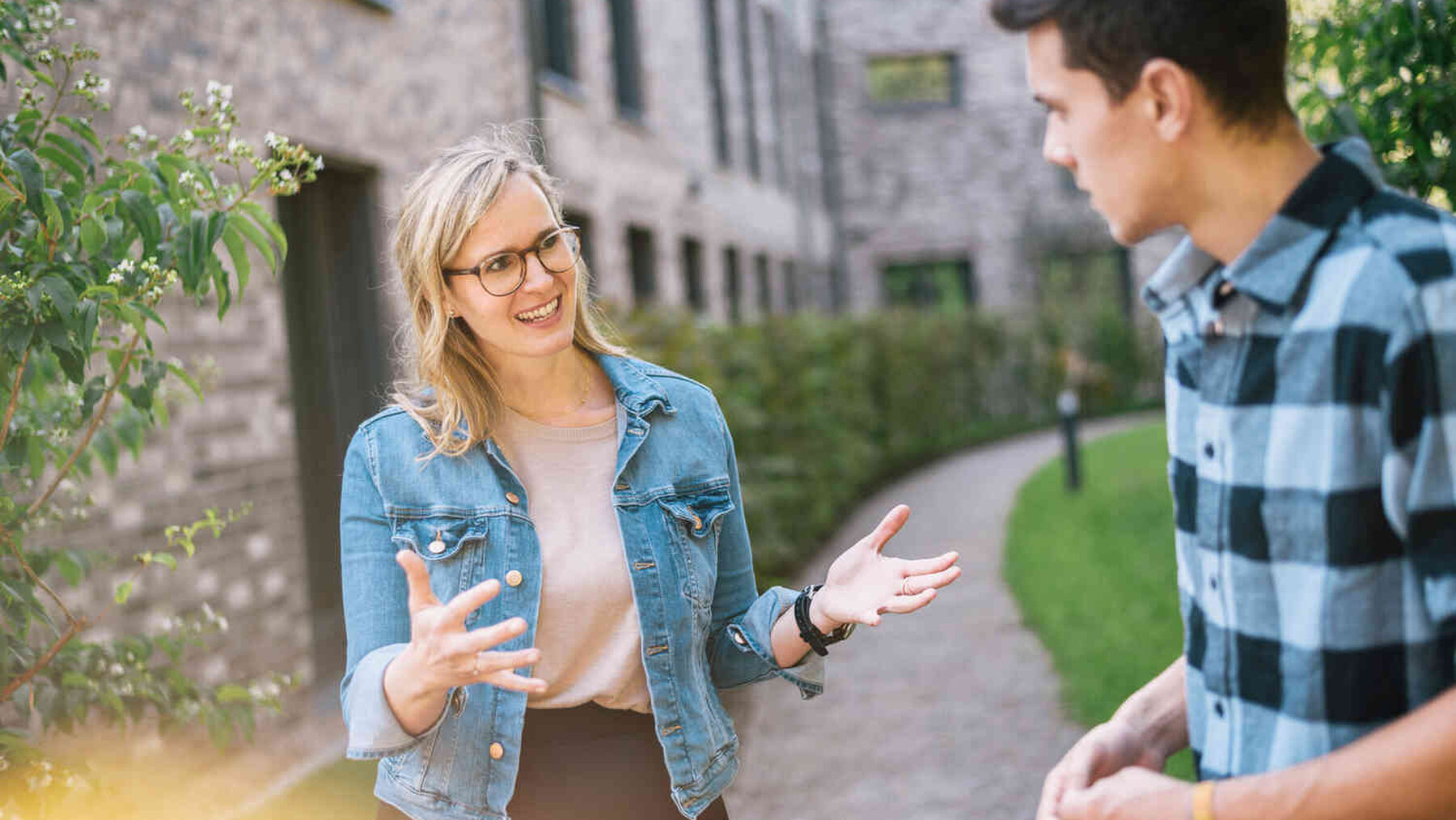 Frau und Mann sprechen im Gr&uuml;nen miteinander