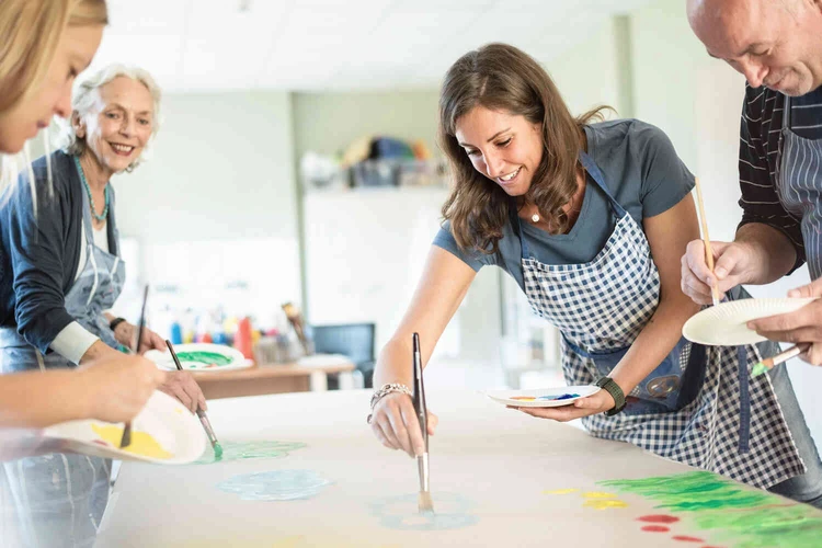 Gruppe malt gemeinsam an einem Tisch