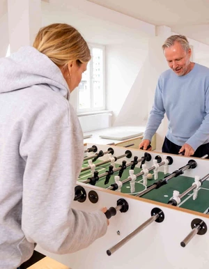 Zwei Personen spielen Tischkicker