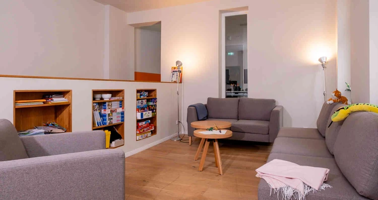 Aufenthaltsraum mit Sofa, Sesseln und Fenster