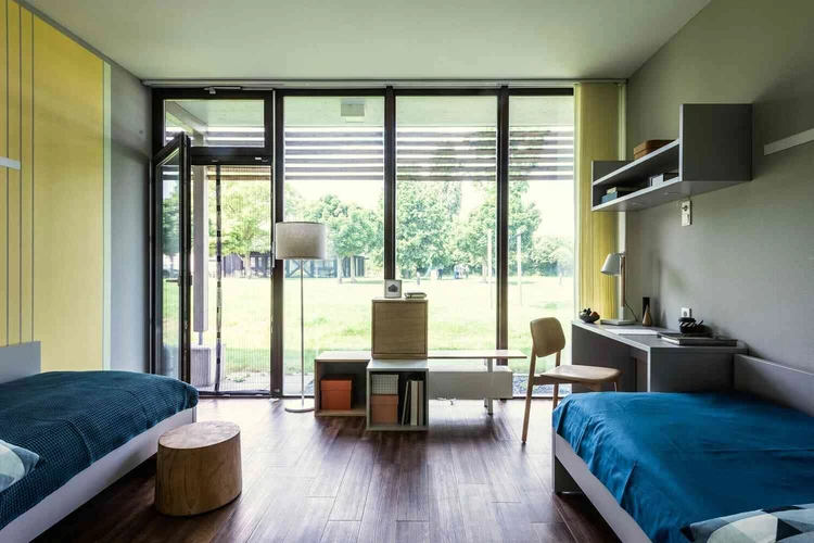 Patientenzimmer mit Bett und Blick in den Garten