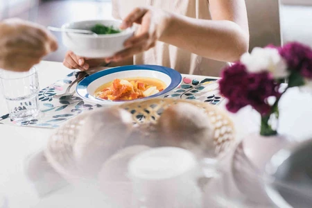 Gedeckter Tisch mit Brotkorb und Suppe