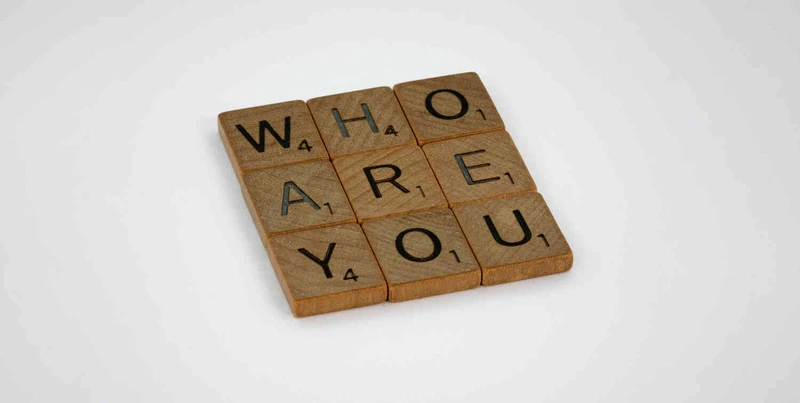 Holzbuchstaben bilden die Frage Who are you