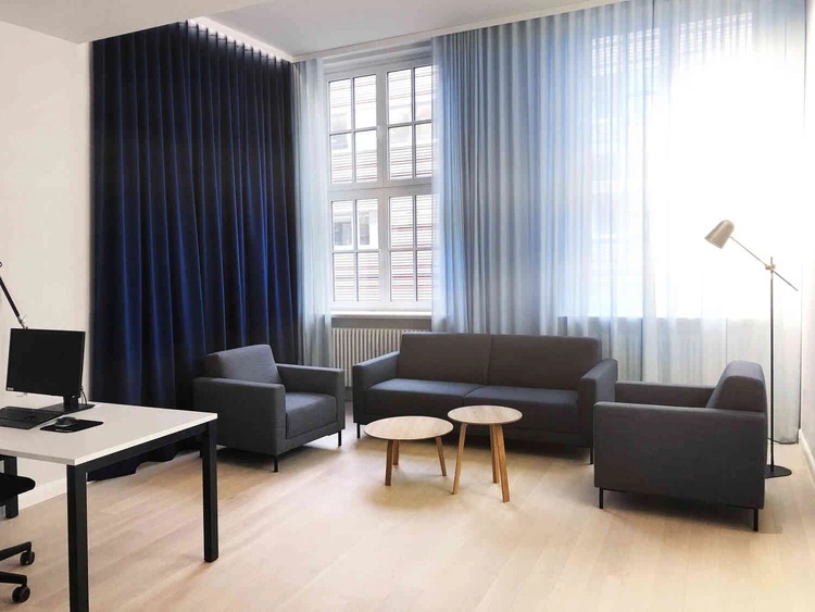 Sitzbereich mit Sofa und Sesseln in einem hellen Raum