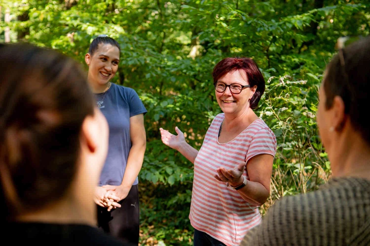Personen bei einer Achtsamkeits&uuml;bung im Wald