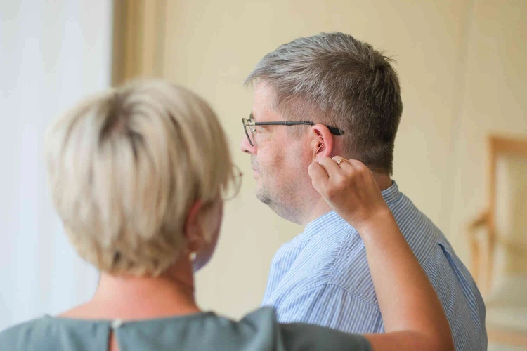 Eine Person erh&auml;lt eine Akupunkturnadel am Ohr