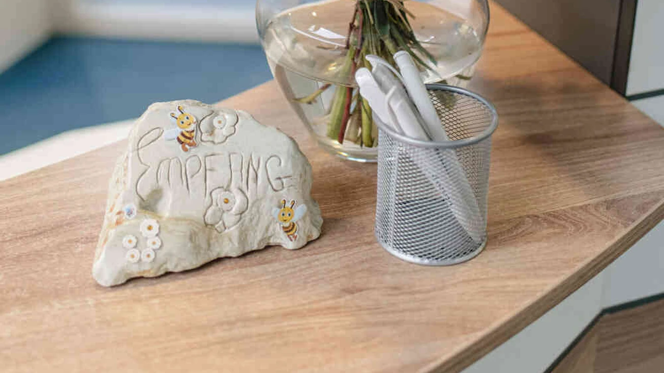 Detailaufnahme eines Beutels und Stifthalters auf einem Tisch neben Blumenstrau&szlig;