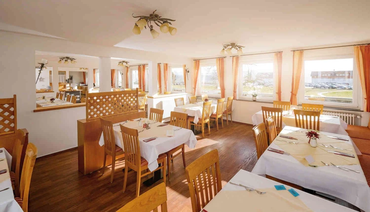 Speiseraum mit gedeckten Tischen und Holzdecke
