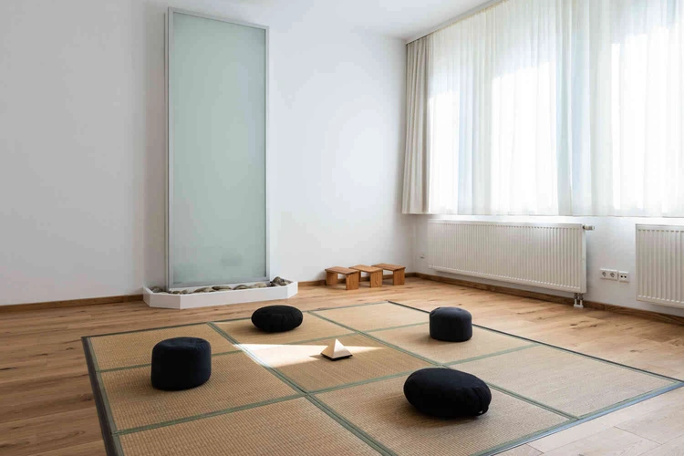 Heller Bewegungsraum mit Sitzkissen und gro&szlig;en Fenstern