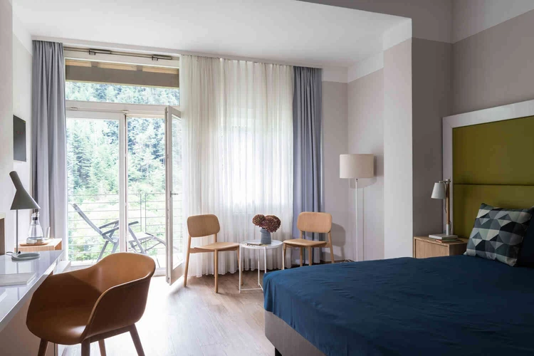 Helles Patientenzimmer mit Bett und gro&szlig;em Fenster