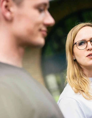 Zwei Personen sprechen im Gr&uuml;nen miteinander