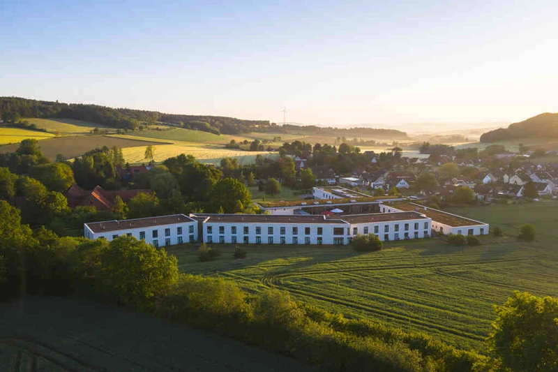 Luftaufnahme der Oberberg Fachklinik Weserbergland zwischen Feldern und Ortschaft