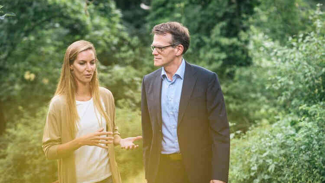 Frau und Mann gehen im Gr&uuml;nen miteinander ins Gespr&auml;ch vertieft